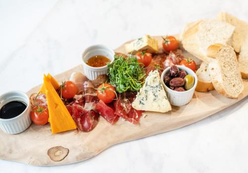 a wooden board with different types of food on it at Novotel Leicester in Leicester