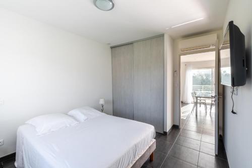 une chambre avec un lit blanc et une télévision dans l'établissement Matteo Laricio, à Peri