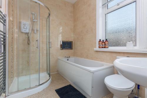 een badkamer met een douche, een toilet en een wastafel bij Raikes Parade Victorian Holiday Home - Blackpool Resort Collection in Blackpool