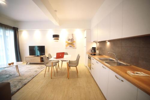 a kitchen with a table and chairs and a kitchen with a tv at Morum Athens Urban Stay in Athens