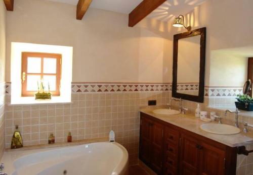 La salle de bains est pourvue de 2 lavabos, d'une baignoire et d'un miroir. dans l'établissement Mirabo ramonet, à Caʼs Concos
