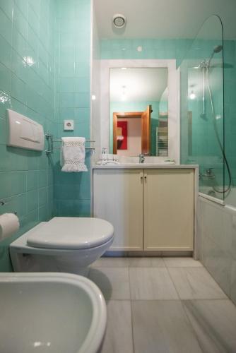 a bathroom with a toilet and a sink and a mirror at Apartamento Portas do Mar I in Matosinhos