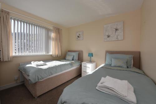 a bedroom with two beds and a window at Riverside 6 in Dartmouth