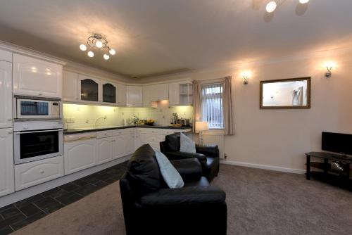 a living room with two chairs and a kitchen at The Mews in Dartmouth