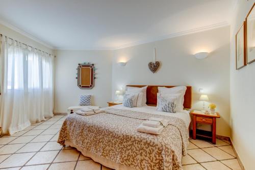 een slaapkamer met een groot bed en 2 handdoeken bij Casa D'Luz in Carvoeiro