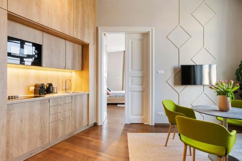 a kitchen with a table and green chairs at Lakeside Budapest Residences in Budapest