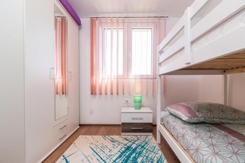 a bedroom with a bunk bed and a window at Selina Ferienwohnung in Loborika