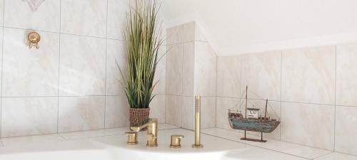 a bathroom with a tub with a plant in it at Ferienwohnungen im Haus Lohme / Hagen in Hagen