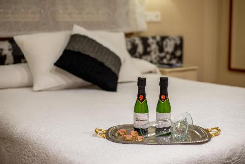 two bottles of champagne on a tray on a bed at Hotel el Pinar in Villapedre