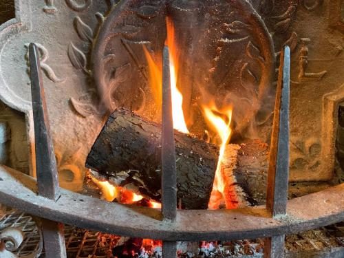 a fire inside of a metal oven with flames at Ye Olde White Harte Hotel in Burnham on Crouch