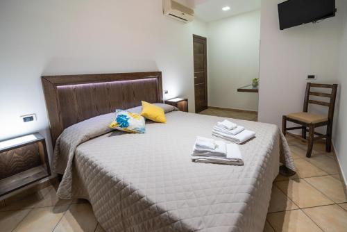 a bedroom with a large bed with towels on it at Perla di Mare Appartamenti in Castelluzzo