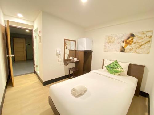 un dormitorio con una cama blanca con sombrero en New Star, en Pattaya central