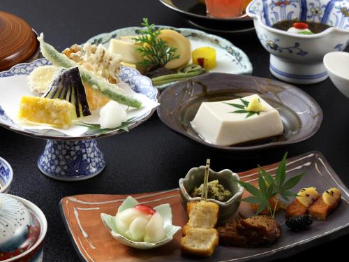 a table with plates of food on a table at Ryokan Koyokan in Yasugi