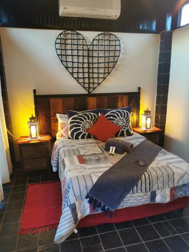 a bedroom with a bed with a heart on the wall at Tula@159 in Bloemfontein