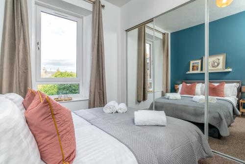 um quarto com 2 camas e um espelho em West Mount Apartments em Aberdeen