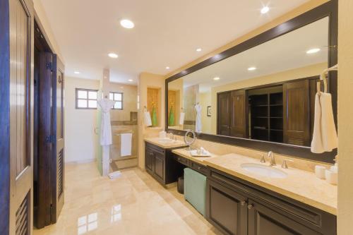 a bathroom with two sinks and a large mirror at Garza Blanca Preserve Resort & Spa in Puerto Vallarta