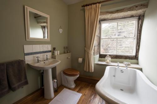 a bathroom with a tub and a sink and a toilet at Swanfold in Hebden Bridge