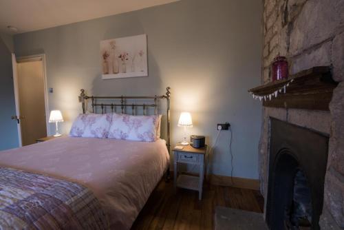 a bedroom with a bed and a fireplace at Swanfold in Hebden Bridge