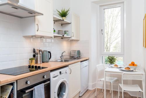 uma cozinha com um lavatório e uma máquina de lavar louça em West Mount Apartments em Aberdeen