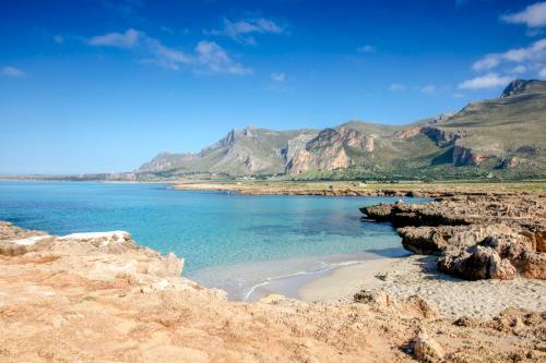 a view of a beach with mountains in the background at Perla di Mare Appartamenti in Castelluzzo