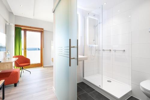 a bathroom with a shower and a toilet and a sink at Hotel Olympia Schießanlage in Garching bei München