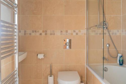 y baño con ducha, aseo y lavamanos. en Montpellier Apartment- The Heart of Harrogate Town Centre- One minute walk from the Famous Betty's Tea room extremely quiet entire apartment with homely living room huge TV and sound bar with a huge comfy Super King size beds sleeps four, en Harrogate