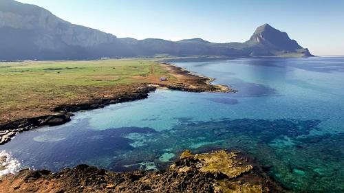 an aerial view of the ocean with mountains in the background at Perla di Mare Appartamenti in Castelluzzo