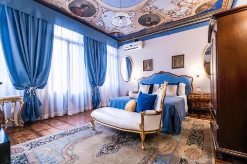 a bedroom with a blue bed and a chair at Ca' Lavezzera in Venice