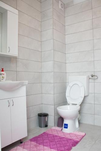 een badkamer met een toilet en een roze kleed bij Stan na dan Doboj in Doboj