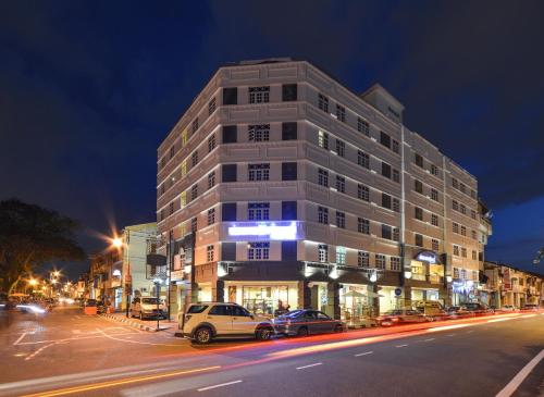 a tall building on a city street at night at Armenian Street Heritage Hotel in George Town
