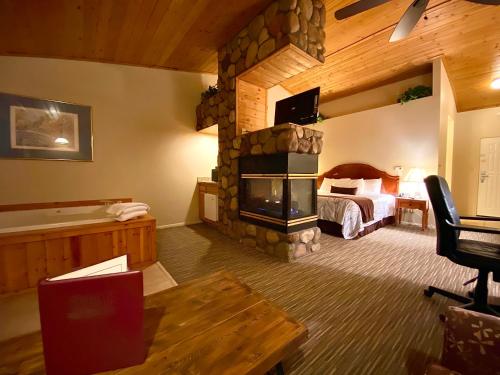 Habitación de hotel con chimenea de piedra en un dormitorio en Majestic Mountain Inn en Payson