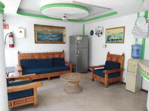 sala de estar con sofá, sillas y nevera en Hotel Montemar, en Acapulco