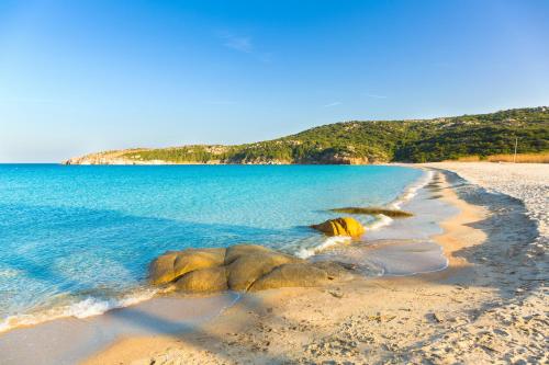 a beach with rocks in the water at Costa Paradiso Resort in Costa Paradiso