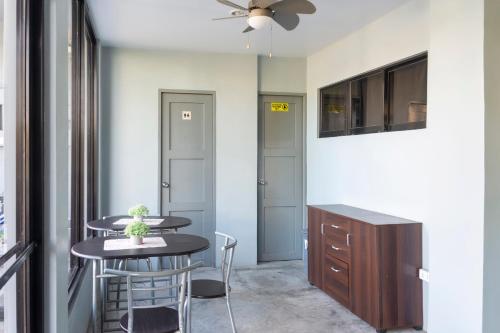 une salle à manger avec une table, des chaises et un ventilateur de plafond dans l'établissement OYO 561 Abn Hostel, à Bacolod