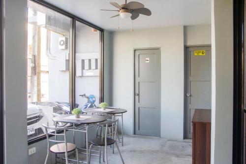 a dining room with two tables and a ceiling fan at Abn Hostel in Bacolod