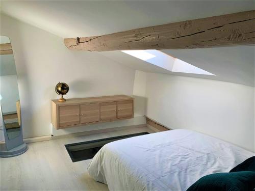 een slaapkamer met een wit bed en een dakraam bij LE FOCH in Aix-en-Provence