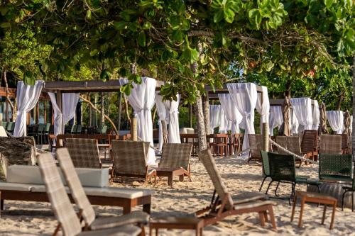 a group of chairs and tables on the beach at Kûara Hotel in Arraial d'Ajuda