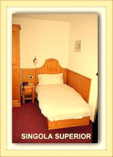 a bedroom with a bed in a hotel room at Hotel Beau Sejour in Etroubles