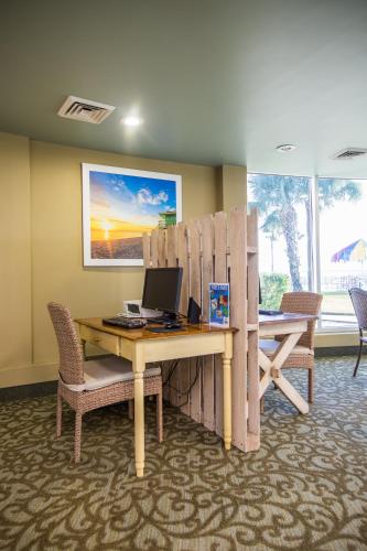 a office with a desk with a computer on it at Days Inn & Suites by Wyndham Jekyll Island in Jekyll Island