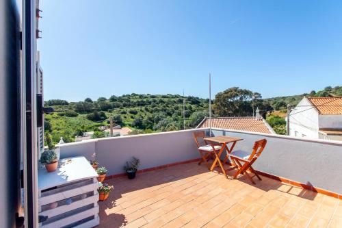 ein Balkon mit Tisch und Stühlen auf einem Dach in der Unterkunft Casa Oceano-Mar a vista in Raposeira