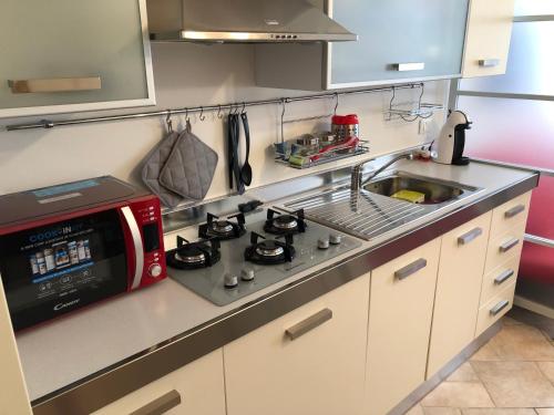 a kitchen with a stove and a microwave at Calle Corbatto in Grado