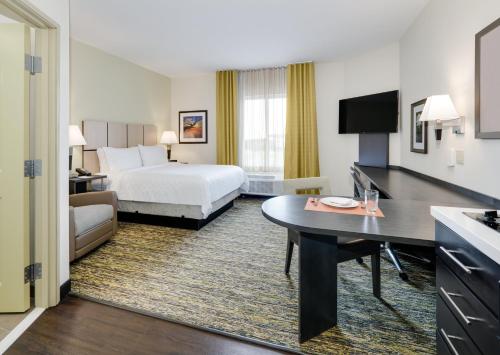 a hotel room with a bed and a desk at Candlewood Suites Dallas NW - Farmers Branch by IHG in Farmers Branch