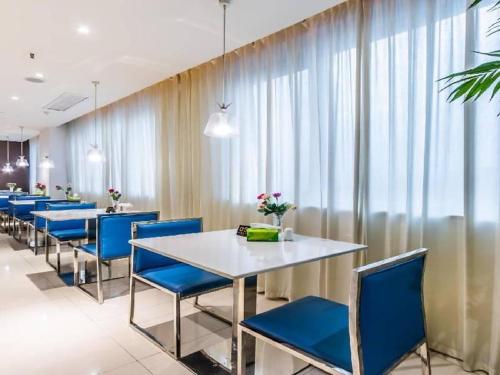 a dining room with blue chairs and tables at Jinjiang Inn Select Hangzhou Binjiang University Town Puyan Metro Station in Hangzhou