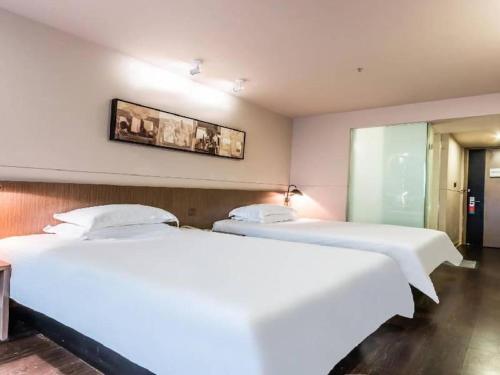 Ένα ή περισσότερα κρεβάτια σε δωμάτιο στο Jinjiang Inn Select Hangzhou Binjiang University Town Puyan Metro Station
