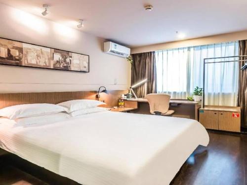 Ένα ή περισσότερα κρεβάτια σε δωμάτιο στο Jinjiang Inn Select Hangzhou Binjiang University Town Puyan Metro Station