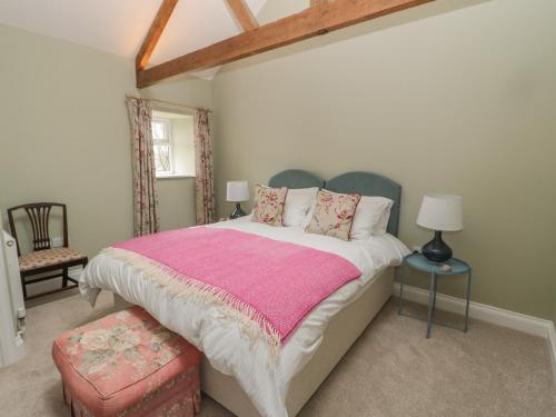 a bedroom with a large bed with a pink blanket at Todridge Barn in Newcastle upon Tyne