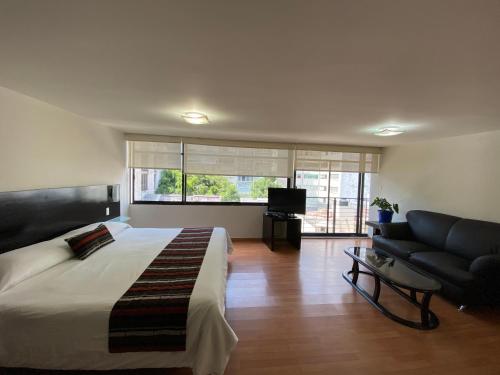 a bedroom with a bed and a couch and a television at Grupo Kings Suites -Platon 436 in Mexico City