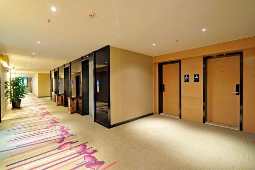 a hallway with a row of elevators in a building at Lavande Hotels·Guiyaung North Railway Station in Guiyang