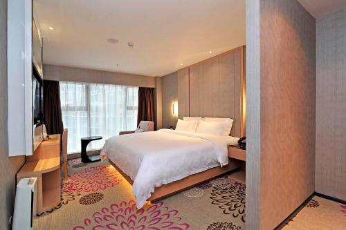 a hotel room with a large bed and a television at Lavande Hotels·Guiyaung North Railway Station in Guiyang