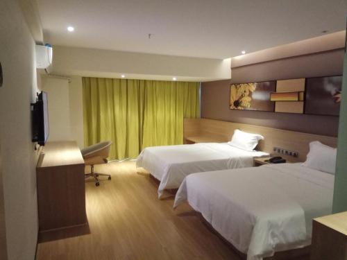 IU Hotel Guiyang Jinyang Century City Shopping Center Chayuan Village Metro Vanke tesisinde bir odada yatak veya yataklar